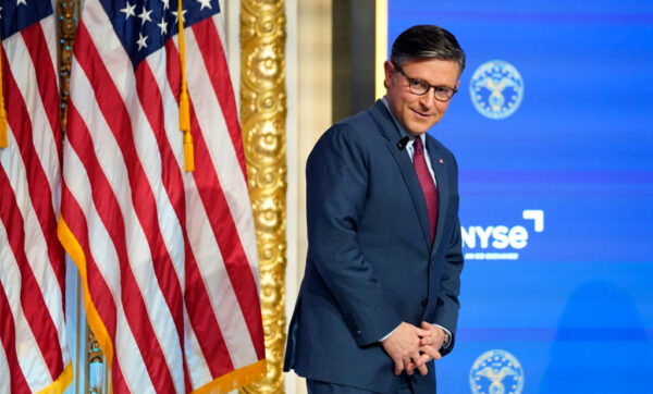 Speaker Mike Johnson stands near a flag at the New York Stock Exchange